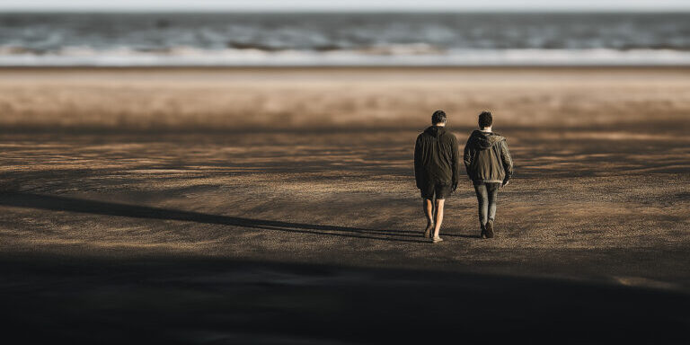 Twee mensen lopen over het strand